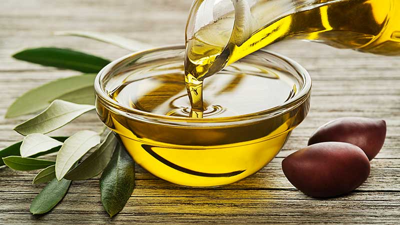 garrafa de azeite a ser despejada tigela 